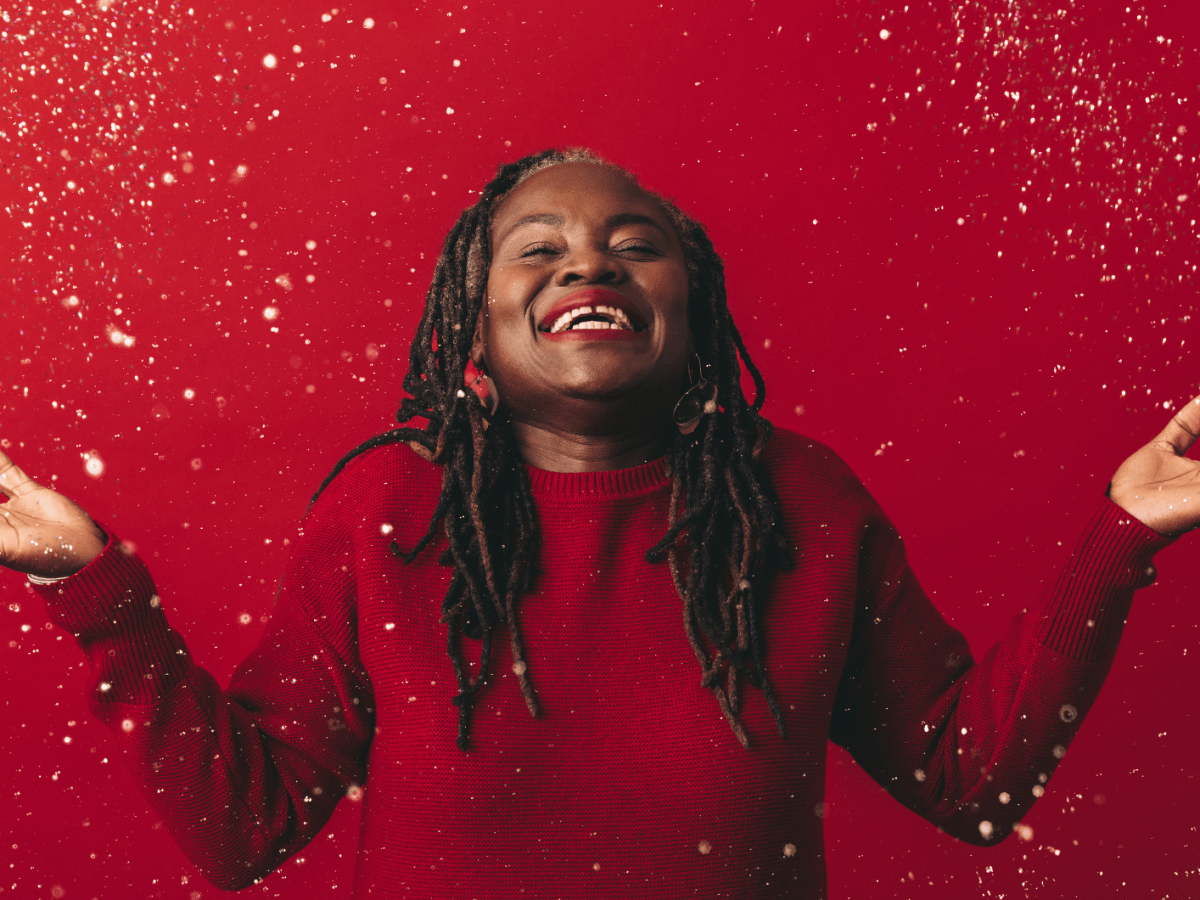 Fr&ouml;hliche reife Frau, die mit Konfetti feiert