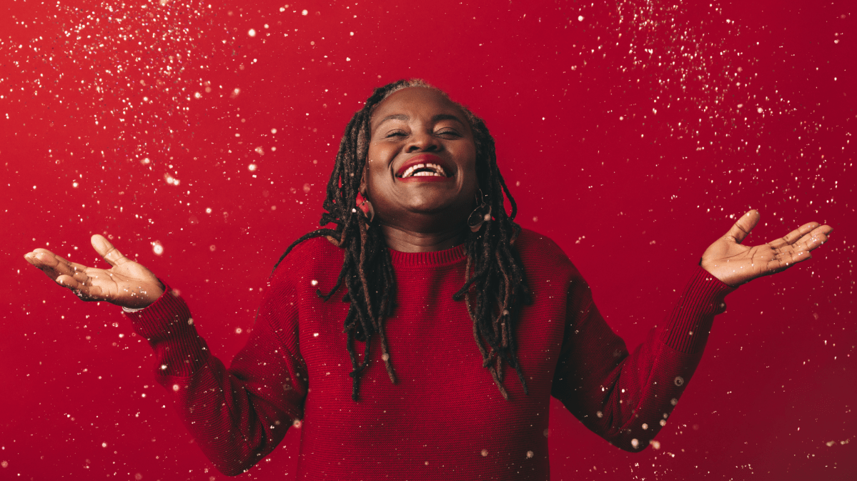 Fröhliche reife Frau, die mit Konfetti feiert