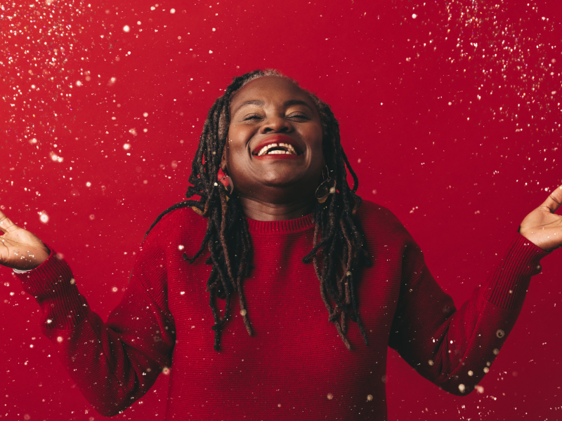 Fröhliche reife Frau, die mit Konfetti feiert