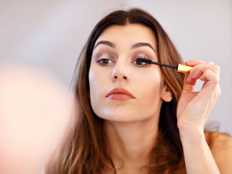 Frau tr&auml;gt Mascara auf