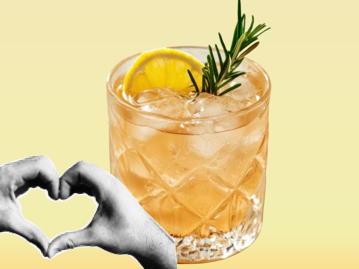 Cocktail mit Eisw&uuml;rfel und Zitrone auf gelbem Hintergrund.