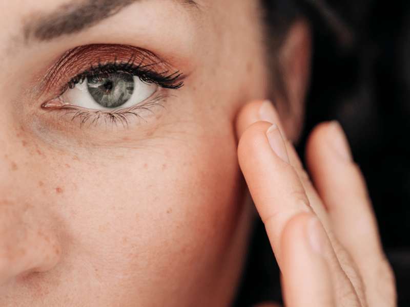 Frau mit intensivem Blick trägt Rouge auf