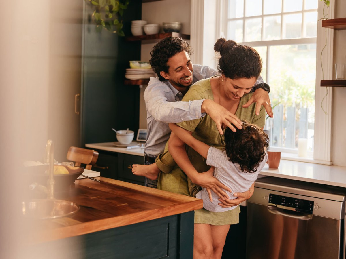 Eltern albern mit ihrem Sohn in der K&uuml;che rum.