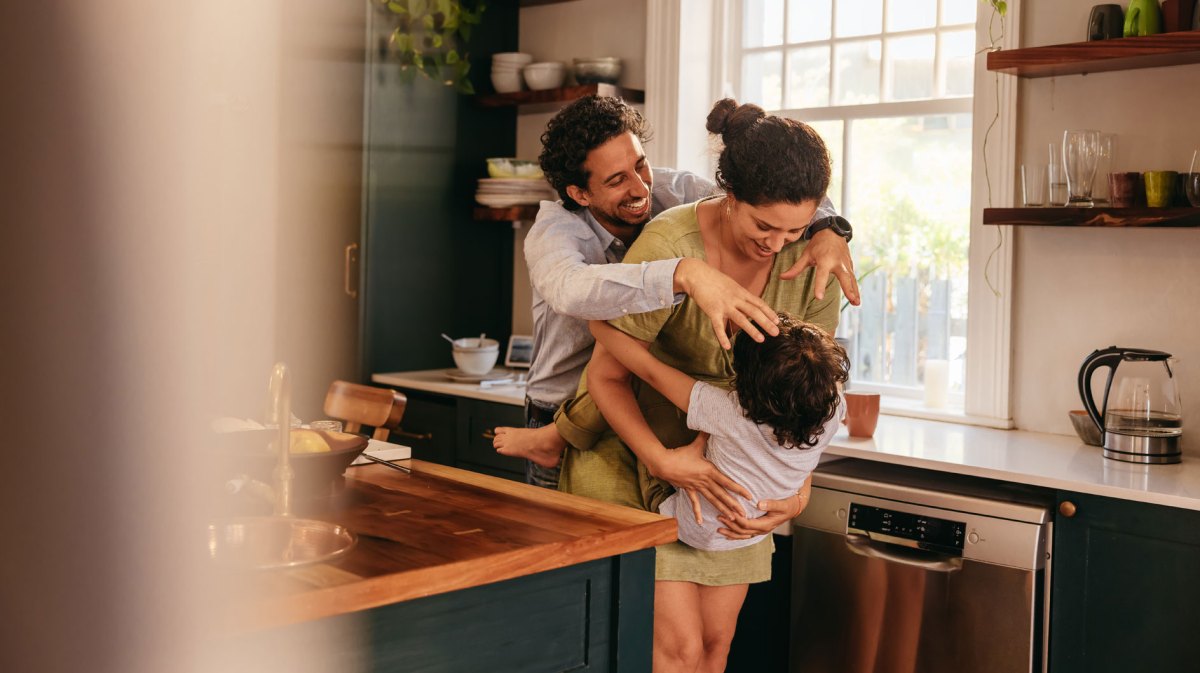 Eltern albern mit ihrem Sohn in der Küche rum.