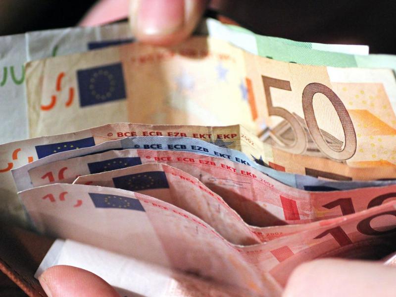 Frau sortiert Geld im Portemonnaie.