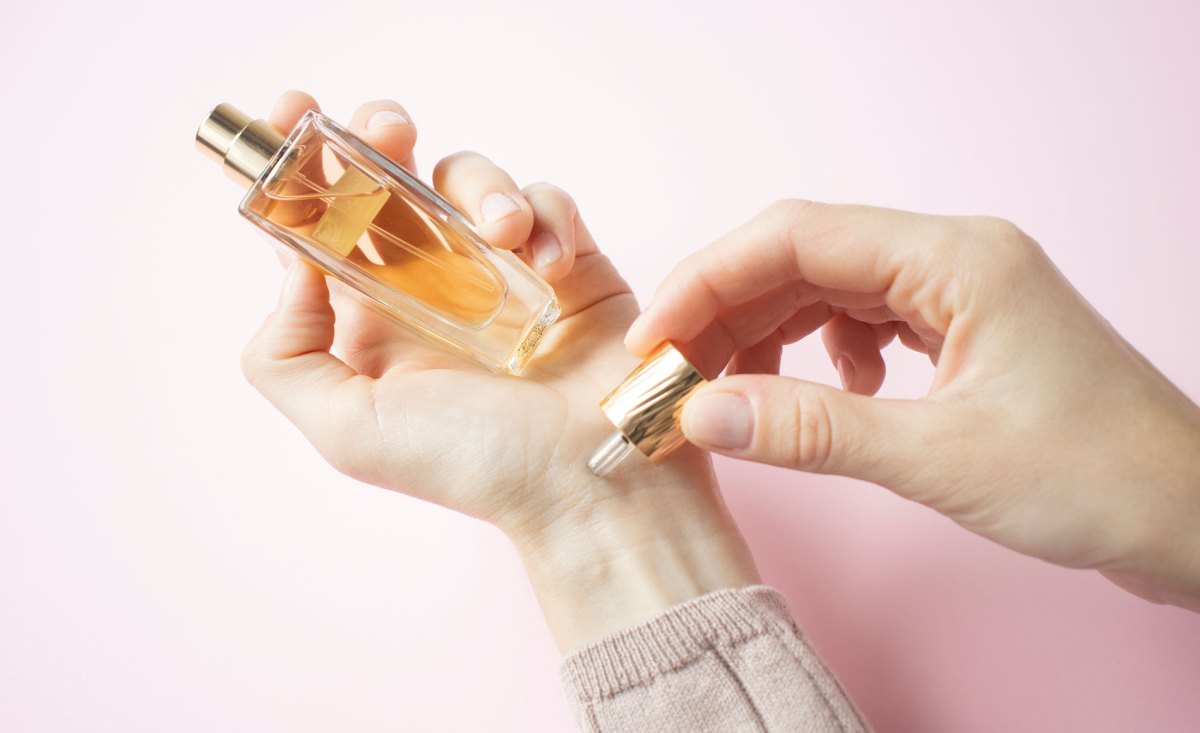 Frau, die Parfum auf Handgelenk aufträgt