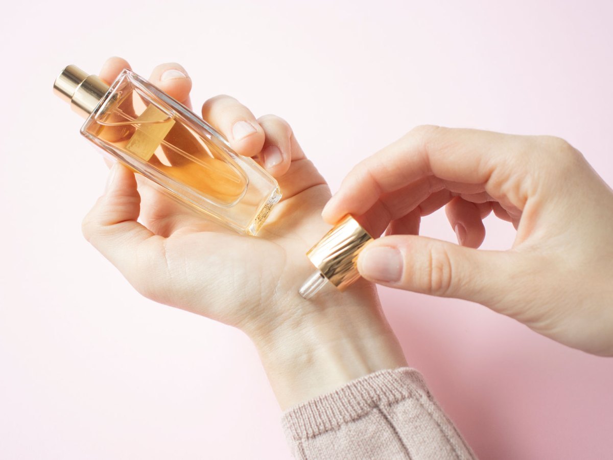 Frau, die Parfum auf Handgelenk aufträgt