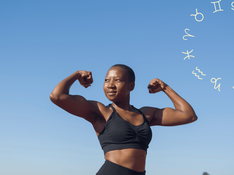Frau vor blauem Himmel flext ihre Armmuskeln