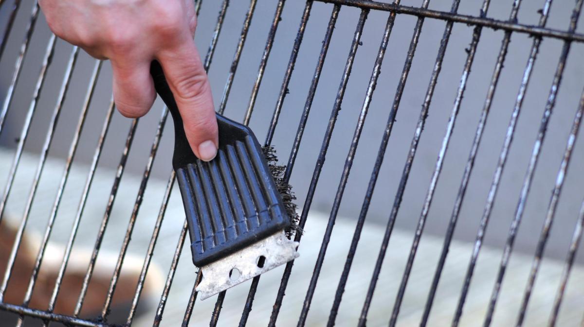 Grillrost wird mit einer Bürste gereinigt.