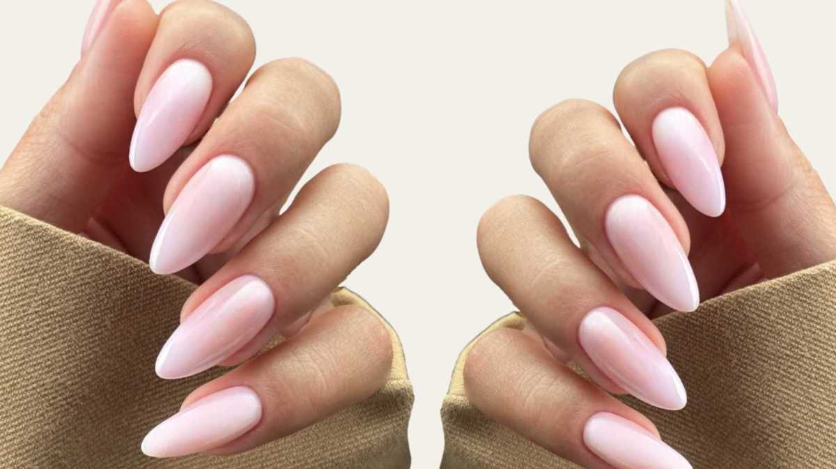 Mandelförmige rosa Nägel vor einem beigen Hintergrund