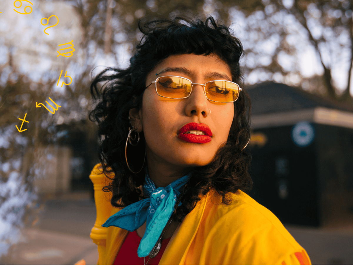 Frau mit gelber Jacke und gelber Sonnenbrille schaut verwundert &uuml;ber die Schulter