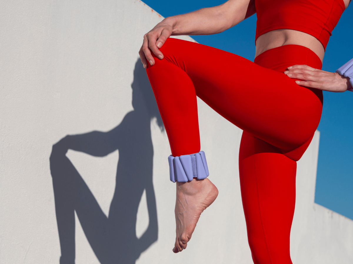 Frau in rotem Fitness-Outfit macht Übungen.