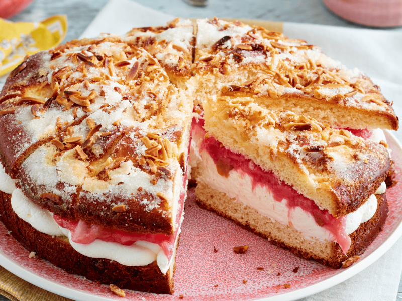 Gefüllter Butterkuchen mit Sahne und Rhabarber auf rosanem Teller.