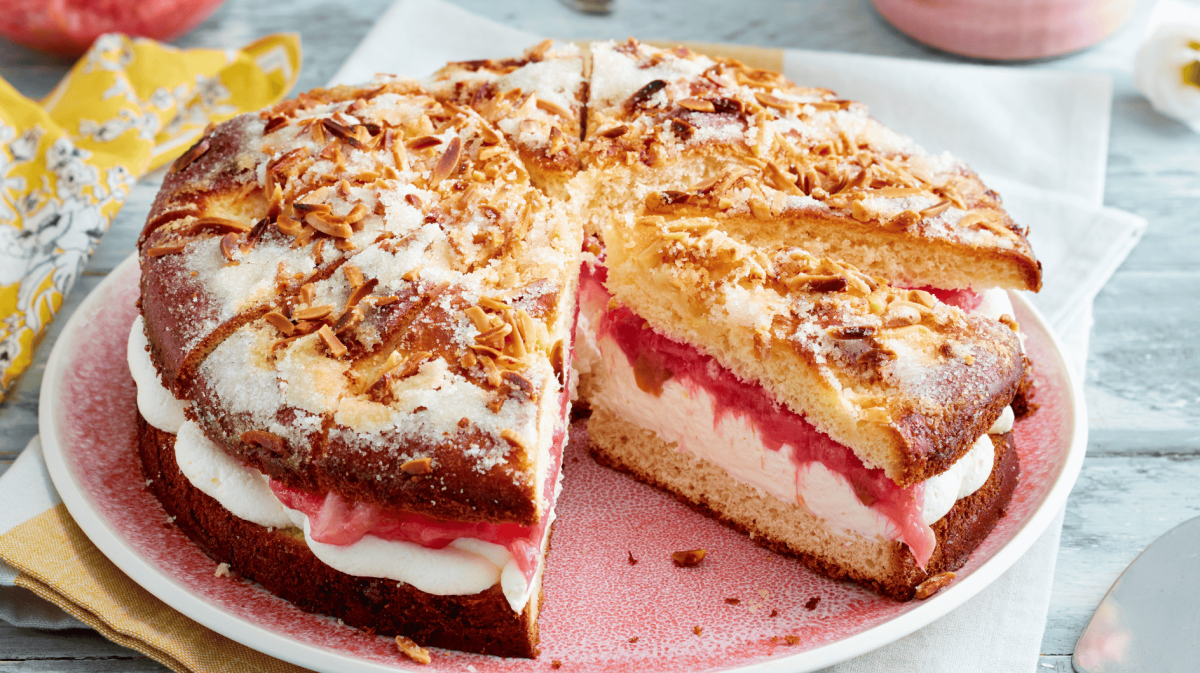 Gefüllter Butterkuchen mit Sahne und Rhabarber auf rosanem Teller.