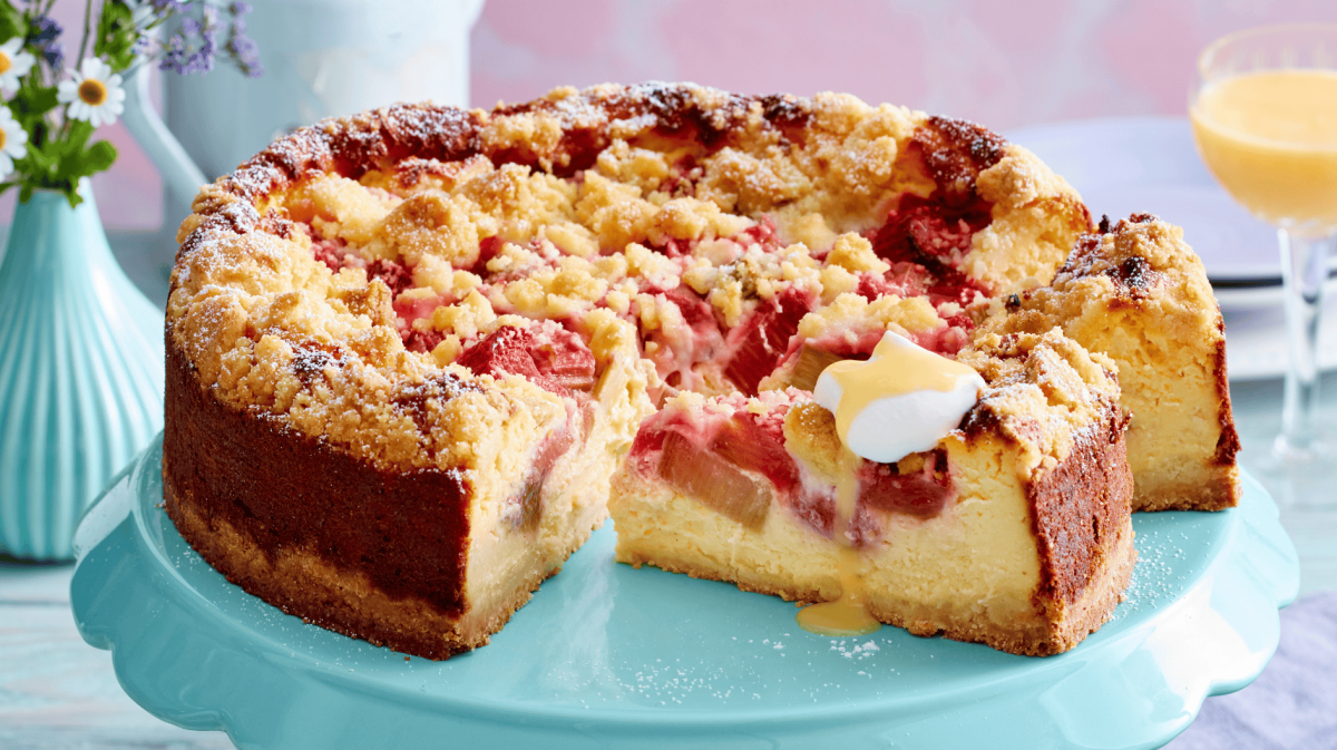 Rhabarber-Käsekuchen auf einer grünen Tortenplatte.
