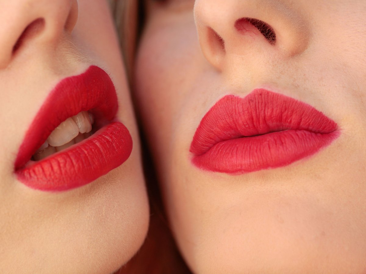 Zwei Frauen mit rot geschminkten Mündern.