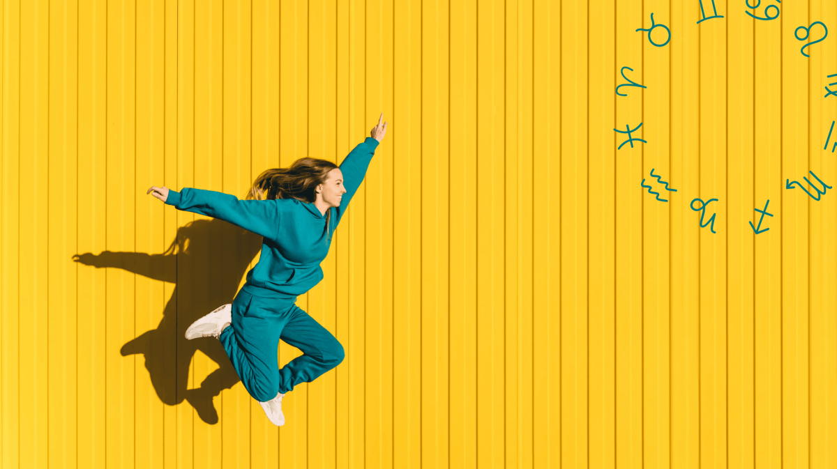 Frau in petrolfarbenen Jogginganzug springt vor gelber Wand