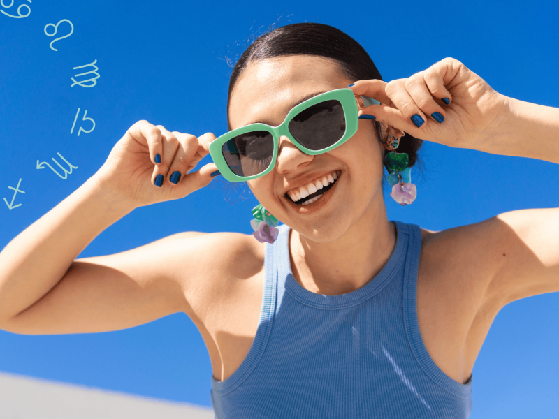 Frau mit Sonnenbrille schaut lächelnd in die Kamera