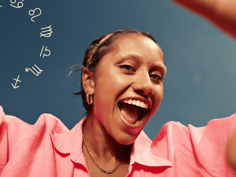 Frau mit rosa Hemd strahlt mit offenem Mund in die Kamera