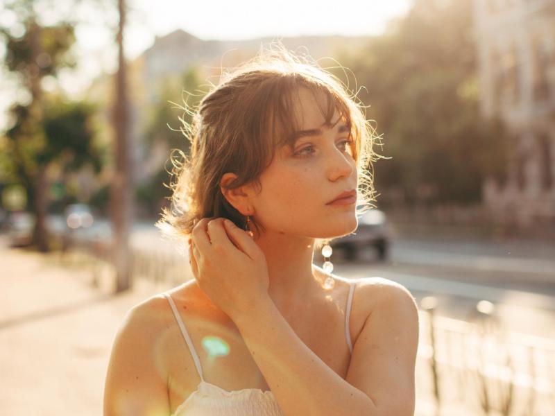 Junge Frau geht durch die Sonne.