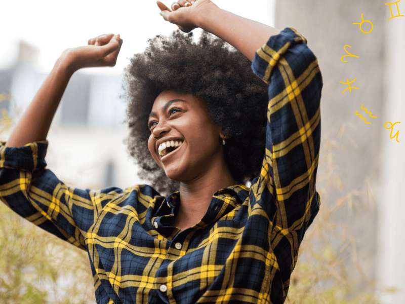 Frau mit kariertem Hemd tanzt und lächelt dabei