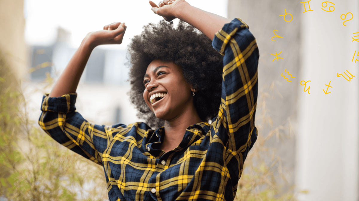 Frau mit kariertem Hemd tanzt und lächelt dabei