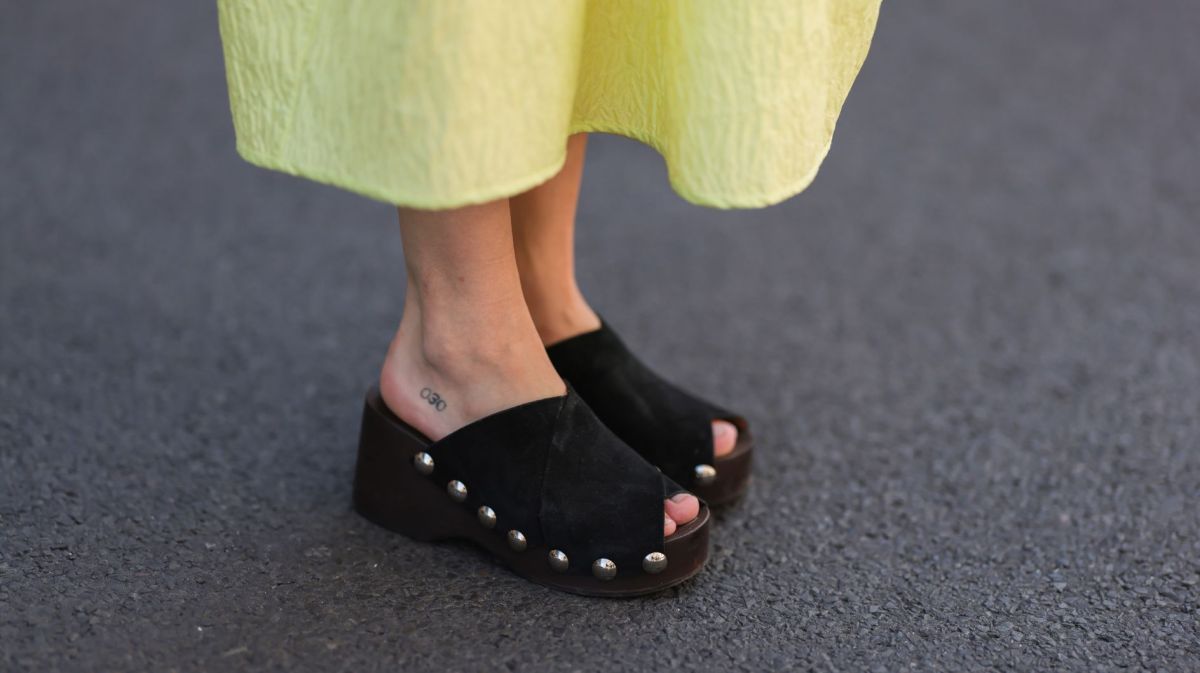Streetstyle von Frau in gelbem Kleid und schwarzen Clogs