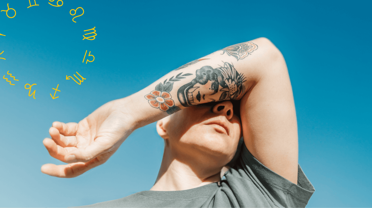 Frau verdeckt mit tätowiertem Arm ihr Gesicht