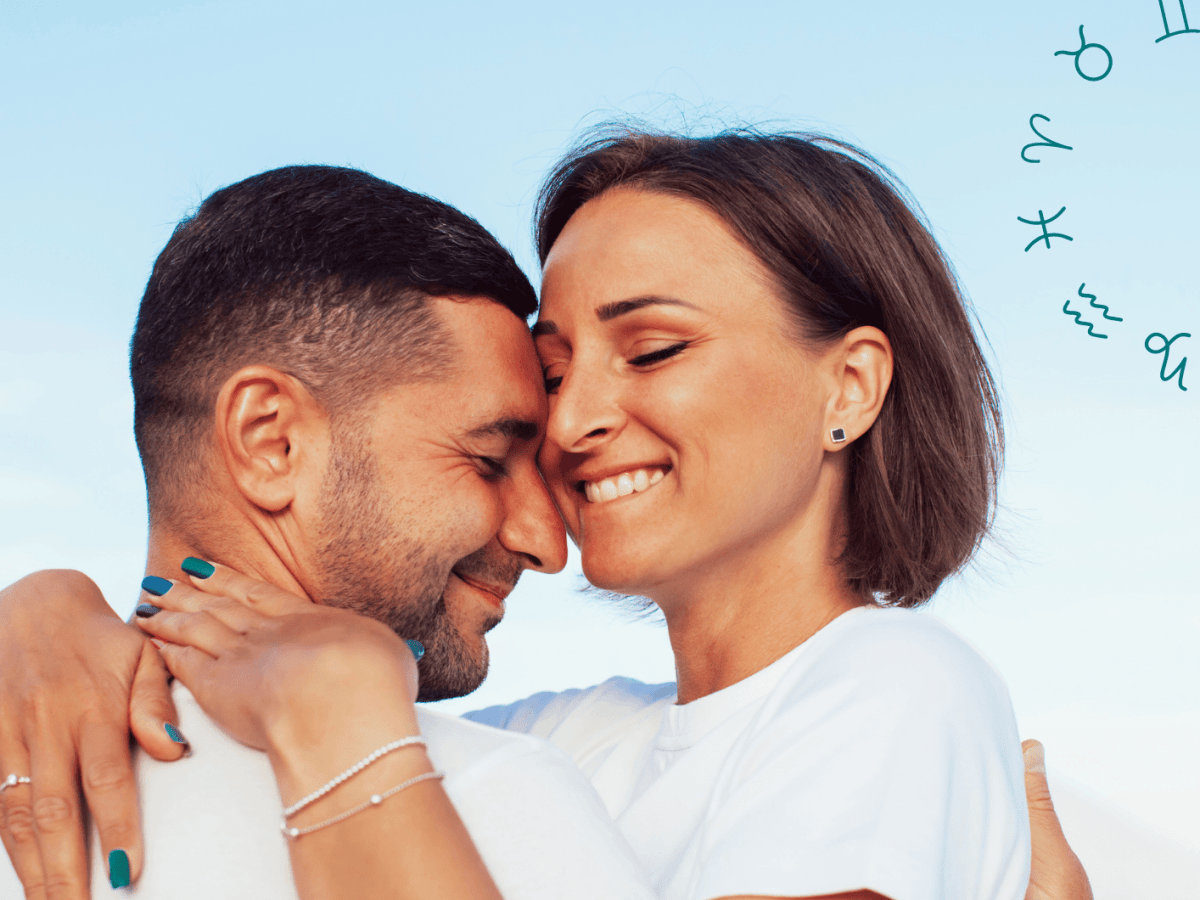 Frau und Mann umarmen sich innig mit geschlossenen Augen unter blauem Himmel.