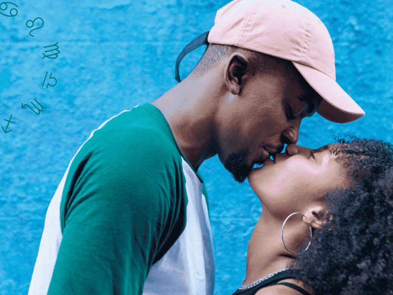 Frau und Mann küssen sich vor blauer Wand