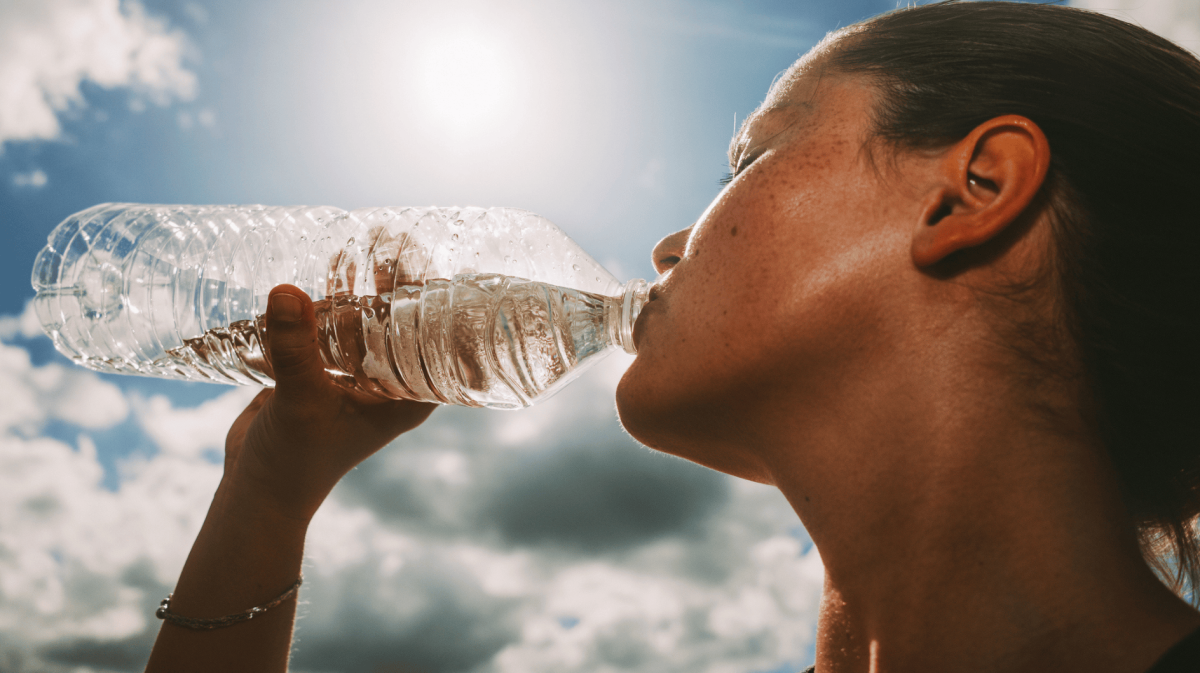 Frau trinkt aus Wasserflasche.