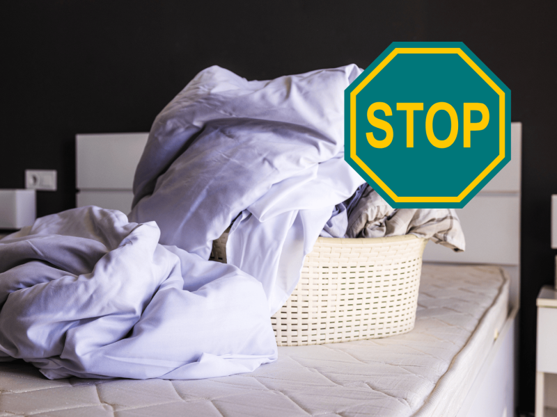 Wäschekorb mit Bettwäsche steht auf einem abgezogenen Bett.