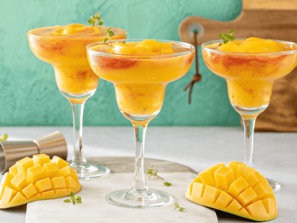 Frozen Mango-Margaritas auf einem hellen Tisch.