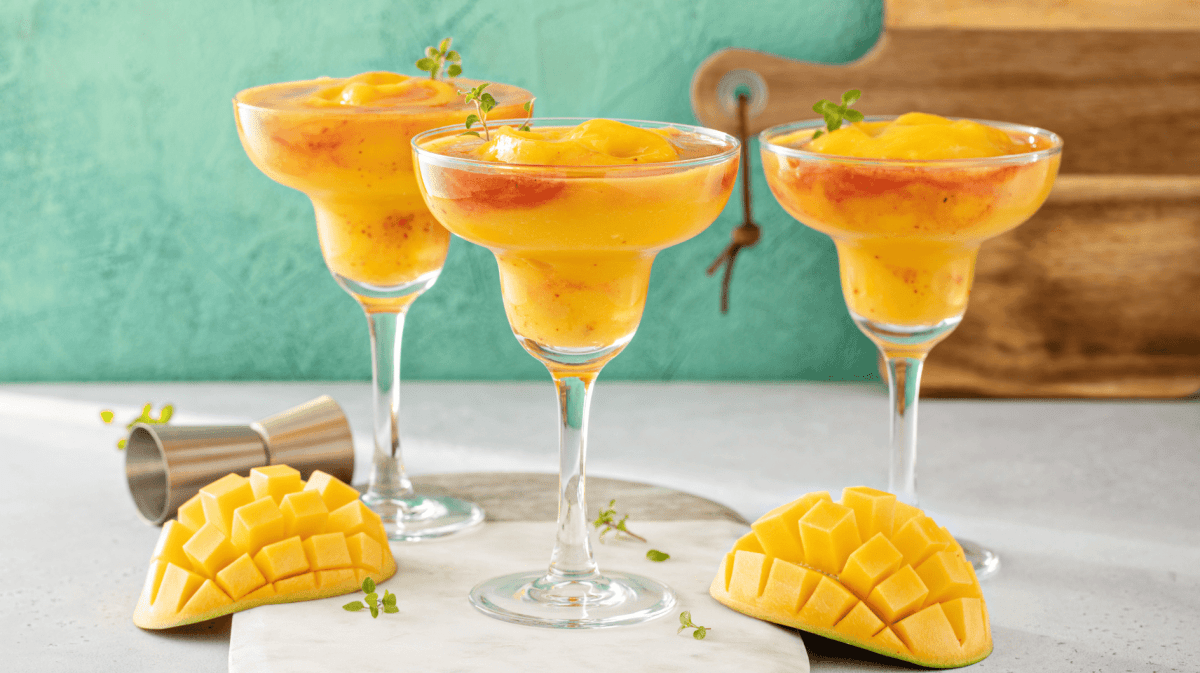Frozen Mango-Margaritas auf einem hellen Tisch.