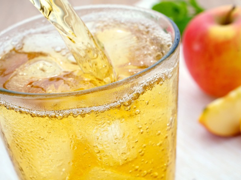 Apfelsaftschorle wir din ein Glas mit Eisw&uuml;rfeln gegossen