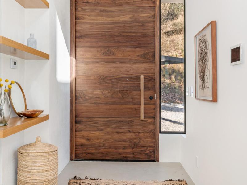 Stylischer Flur mit wertiger Holztür und edlem Regal.