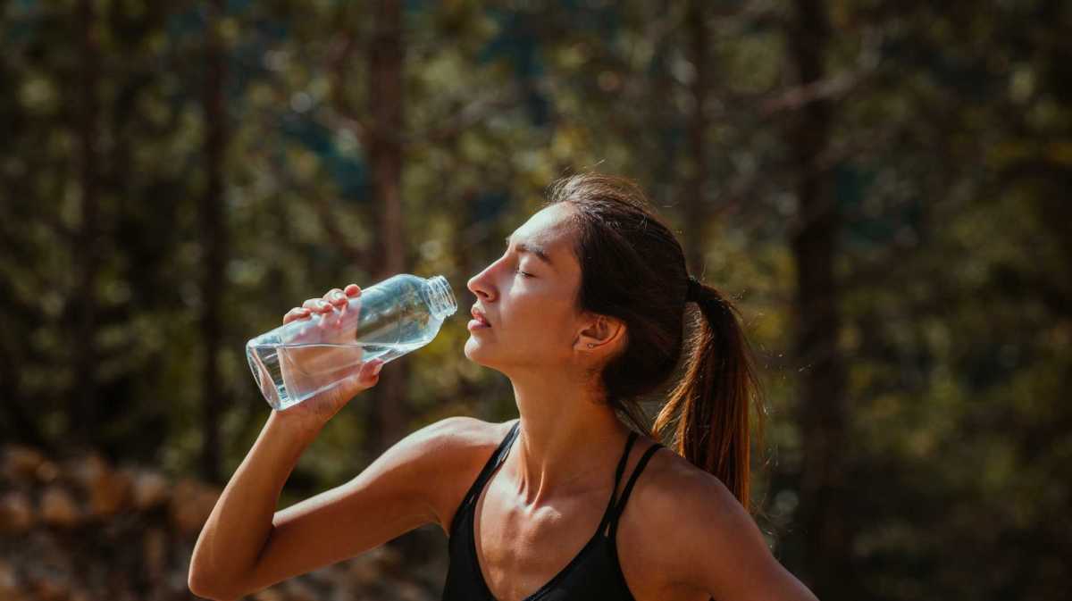 Frau trinkt aus einer Wasserflasche