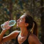 Frau trinkt aus einer Wasserflasche