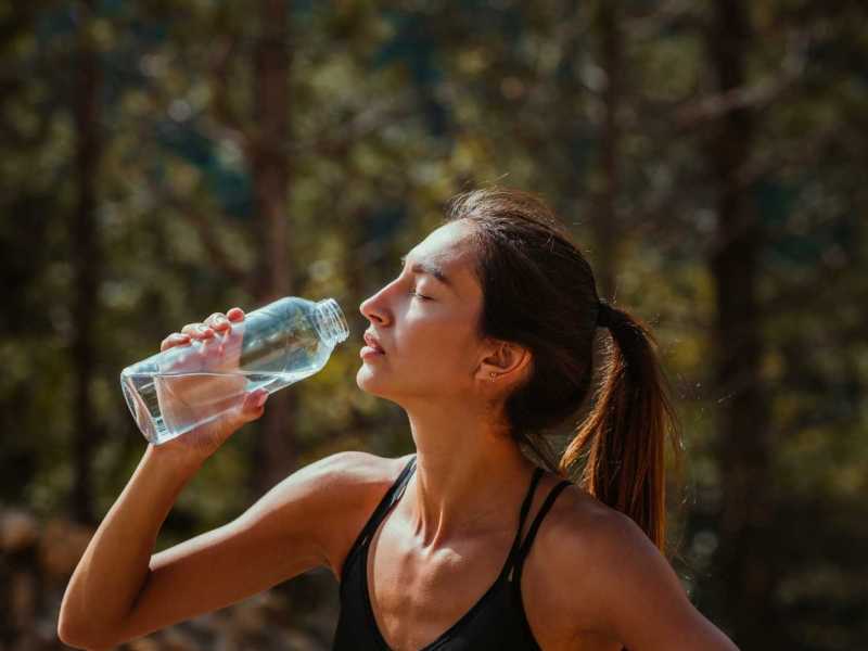 Frau trinkt aus einer Wasserflasche