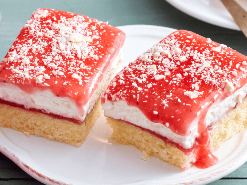 Blechkuchen mit Sahne und Erdbeersoße.
