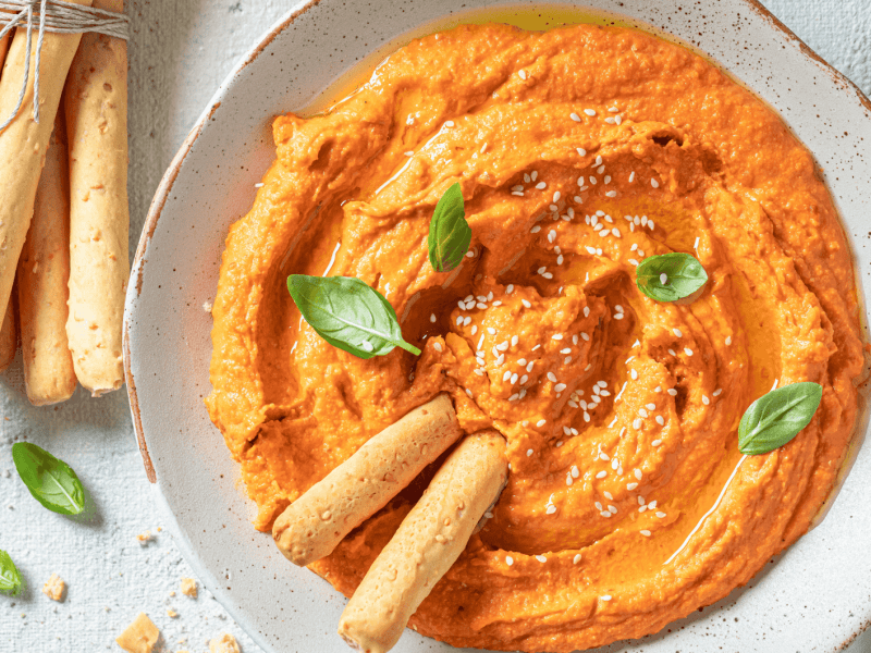 Cremiger Tomate-Mozzarella-Dip in einer weißen Schale.