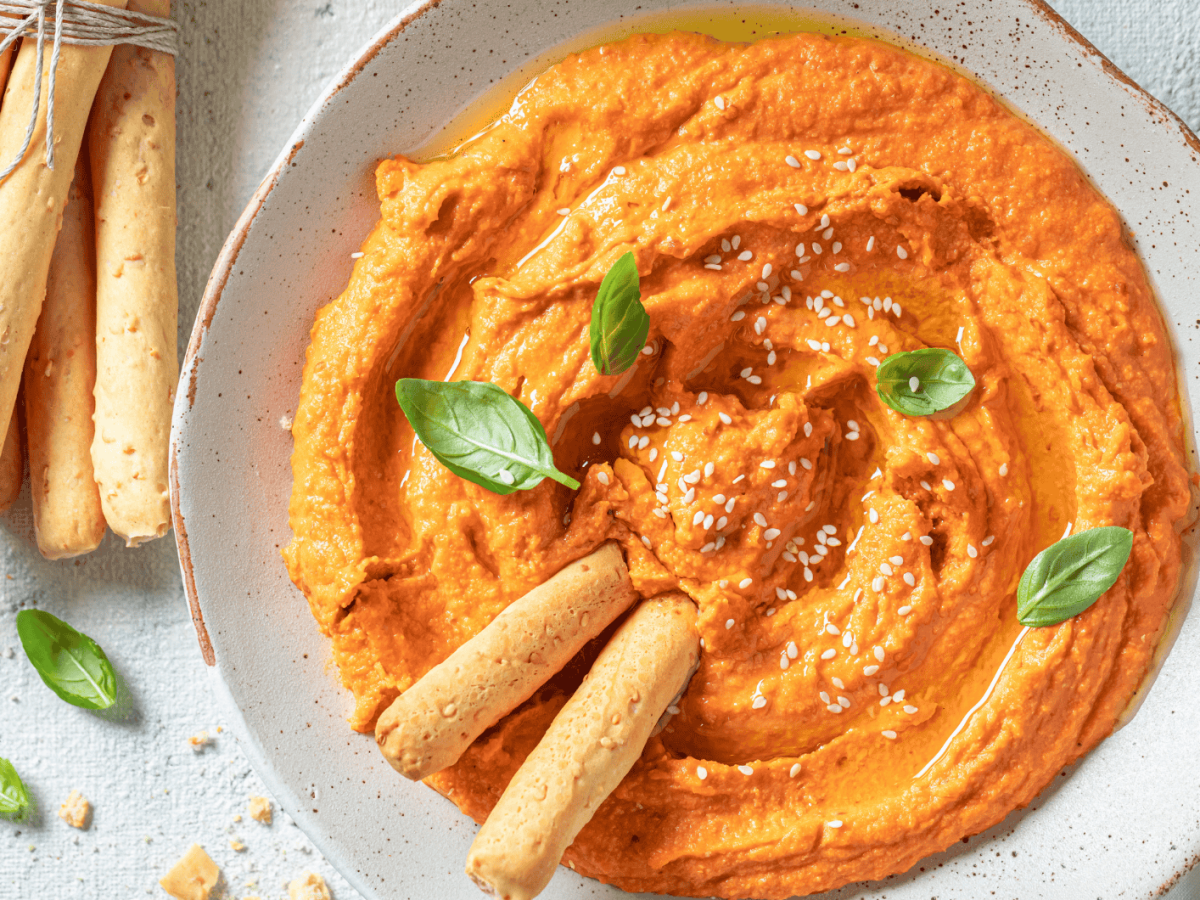 Cremiger Tomate-Mozzarella-Dip in einer wei&szlig;en Schale.