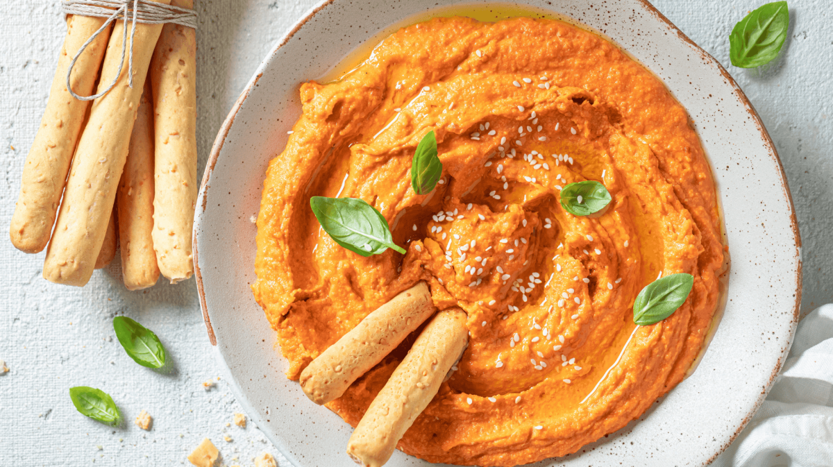 Cremiger Tomate-Mozzarella-Dip in einer weißen Schale.