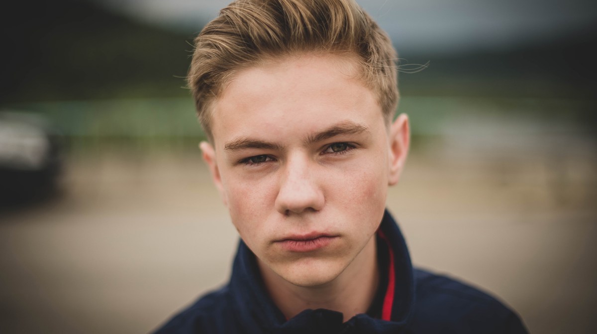 Poträt eines ernst bis wütend schauenden Teenagers draußen.