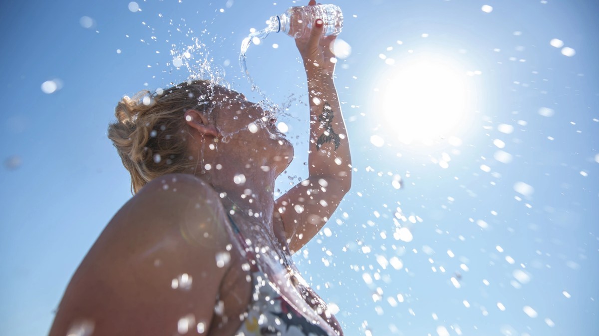 A young woman cools down with cold water during the summer heat