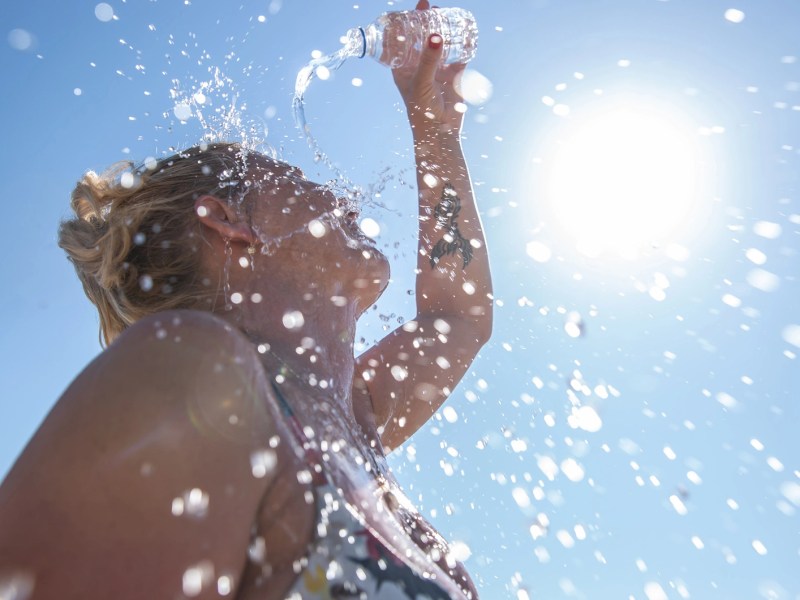 A young woman cools down with cold water during the summer heat