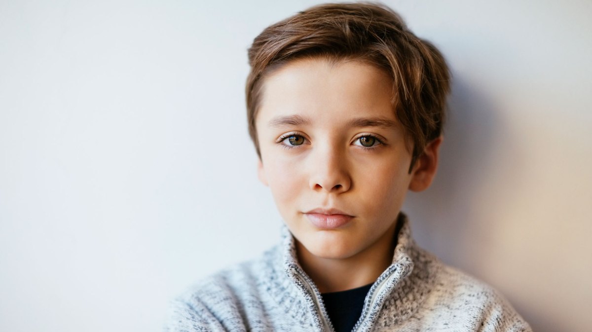 Poträt eines Jungen, ca. 10 Jahre alt, der skeptisch in die Kamera schaut.