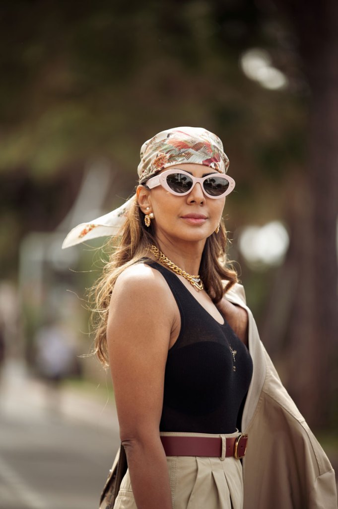 Frau mit Sonnenbrille und gemustertem Tuch am Kopf.