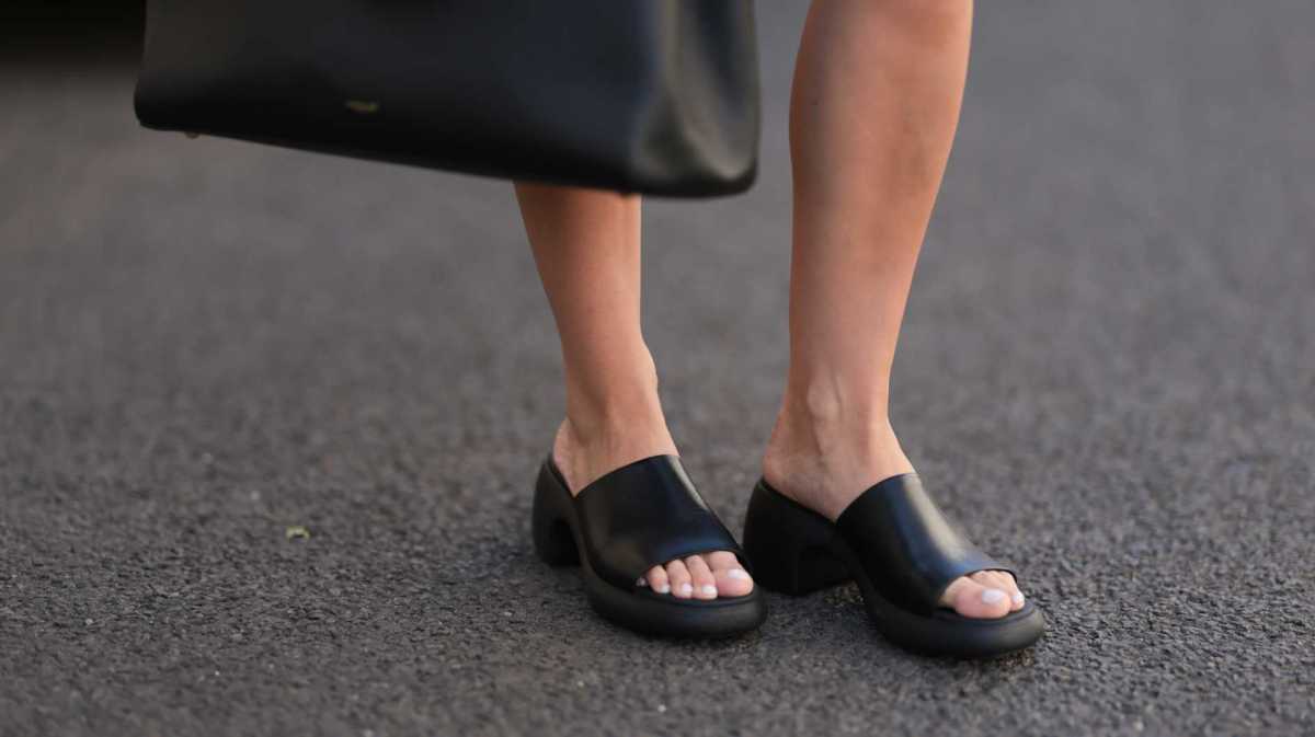 Schwarze Sandalen und lackierte Fußnägel