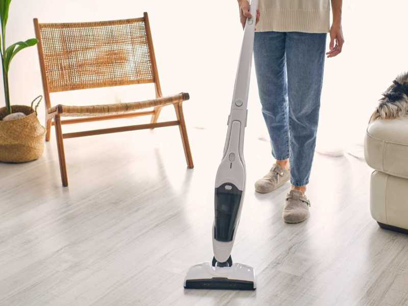 Mann saugt seinen Boden mit einem Staubsauger